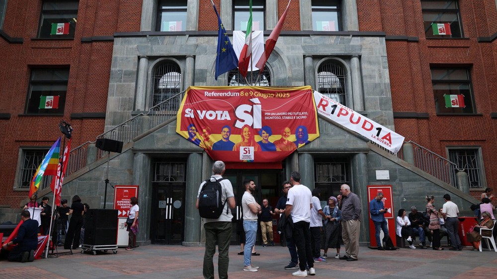 2025年6月4日星期三，在意大利米兰，人们站在支持就就业和意大利公民身份举行五项废除性全民公投的横幅旁。（图：路透社）
