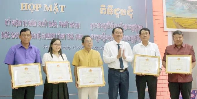 茶荣省人委会副主席阮琼善（右三）向对茶荣省高棉语文艺特刊的发展做出巨大贡献的5名个人颁授奖状。
