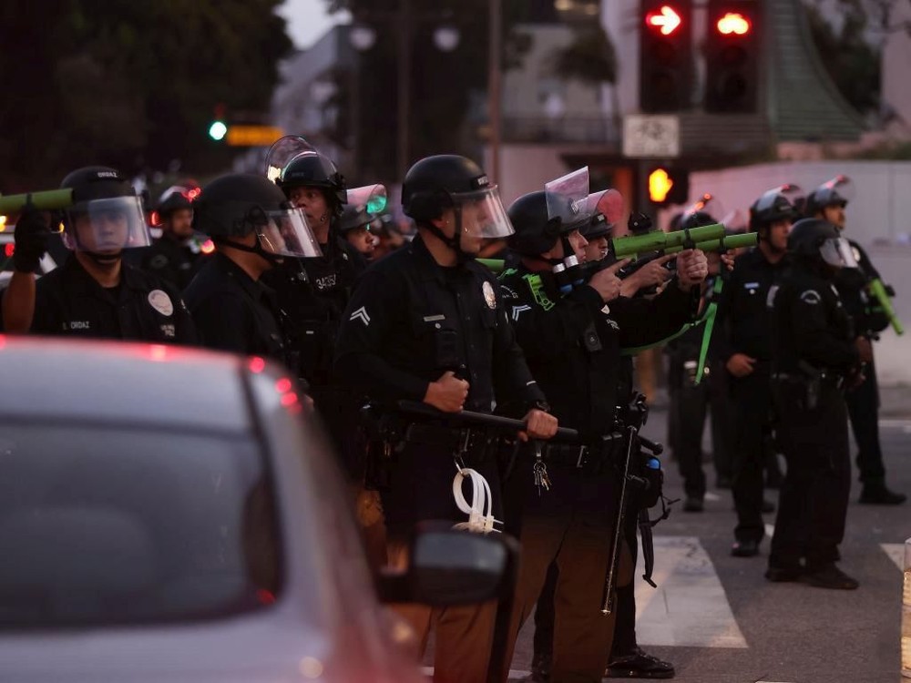 6月10日，在美国加利福尼亚州洛杉矶市中心，警察在宵禁生效后试图驱散街上的人群。（图：新华社）