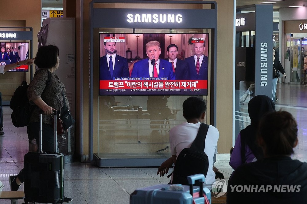 6月22日，在首尔站候车厅，旅客们正在收看美国总统特朗普发表电视讲话的新闻。（图：韩联社）