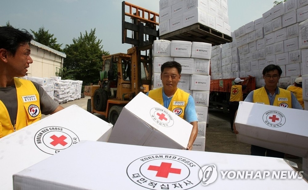 韩国红十字会志愿者搬运对朝人道援助物资，摄于2007年。（图：韩联社）