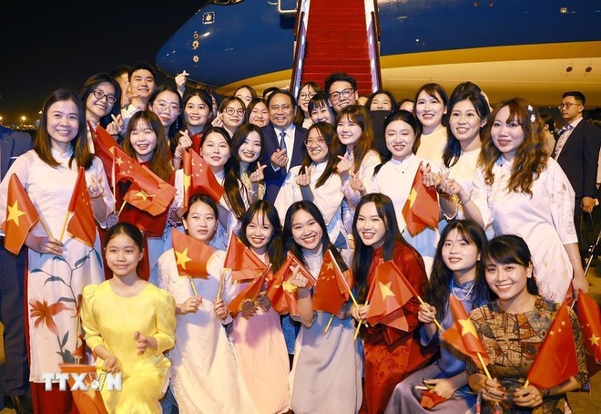 范明政总理与前来送行的在华越侨和留学生合影。（图：越通社）