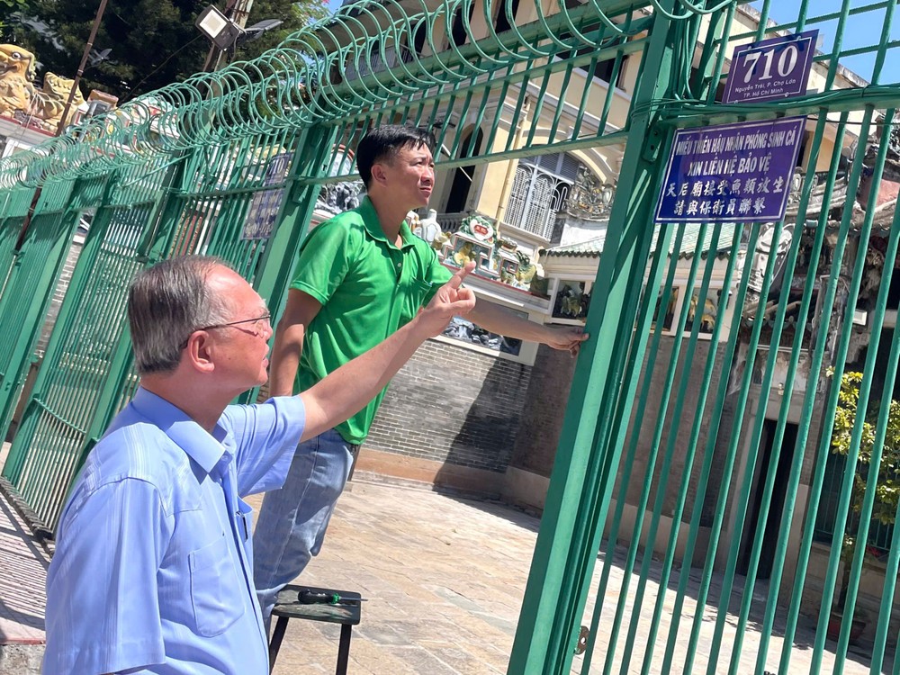 穗城会馆理事长卢耀南指导装新门牌。