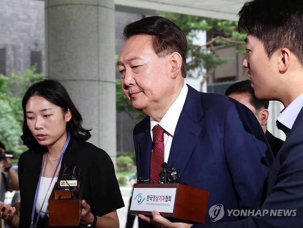 7月5日，在位于首尔瑞草区的首尔高等检察厅，韩国前总统尹锡悦（居中）到案接受内乱叛国案独检组第二次调查。（图：韩联社）