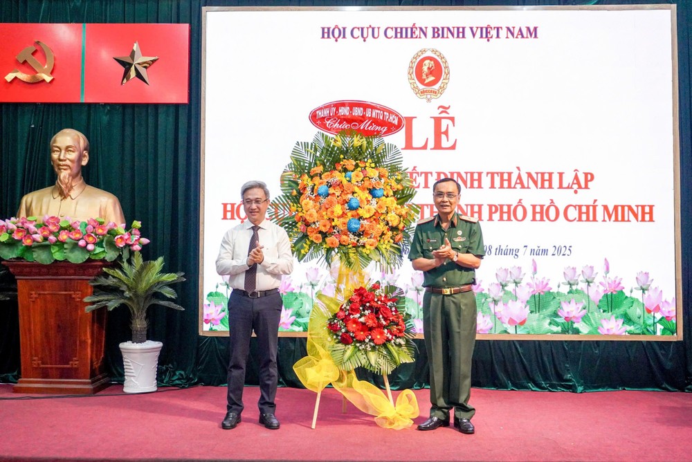 市党委副书记邓明通（左）向退伍军人协会赠送花篮表示祝贺。