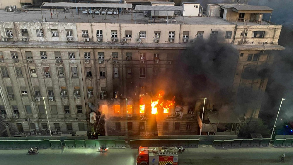 消防人员在埃及首都开罗一座电信大楼的火灾现场工作。（图：新华社）