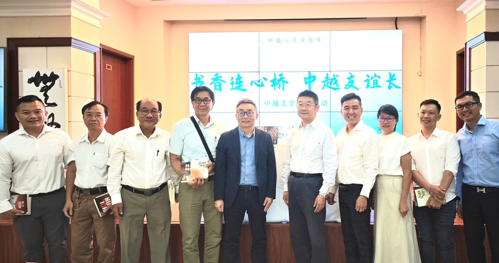 本市华人作家与东西作家（左五）与中国驻本市总领事唐立（左六）合影。