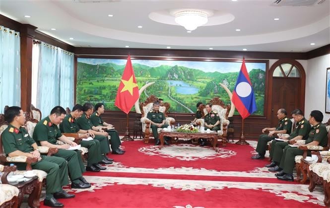 越南国防部副部长阮文贤中将礼节性拜见老挝国防部长坎良·奥萨宋。（图：越通社）