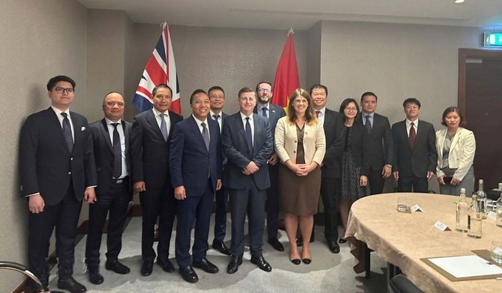 阮黄龙副部长与英国贸易政策国务大臣道格拉斯‧亚历山大及两国各部委、使馆代表在第十四次JETCO会议上合影留念。（图：越通社）