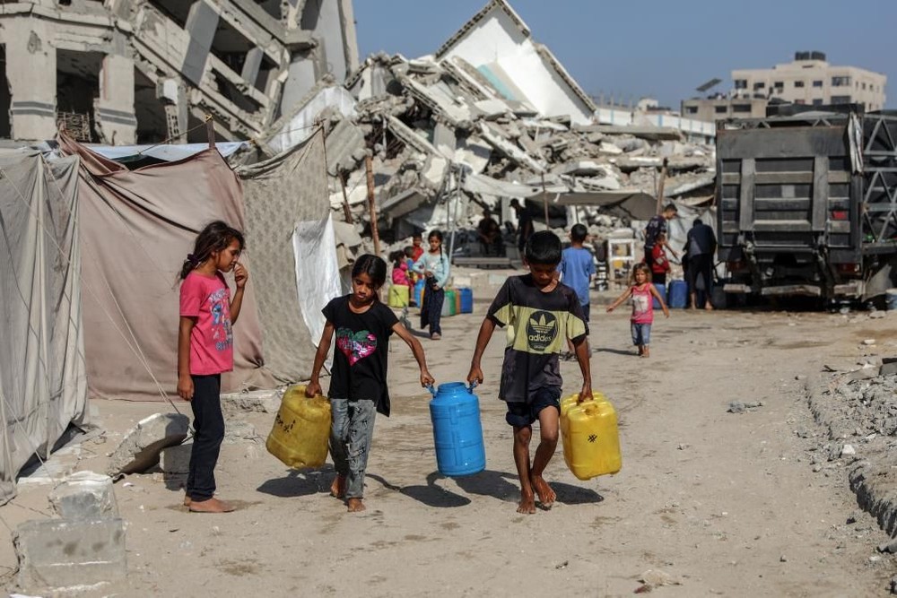 7月17日，巴勒斯坦儿童在加沙城取水。（图：新华社）