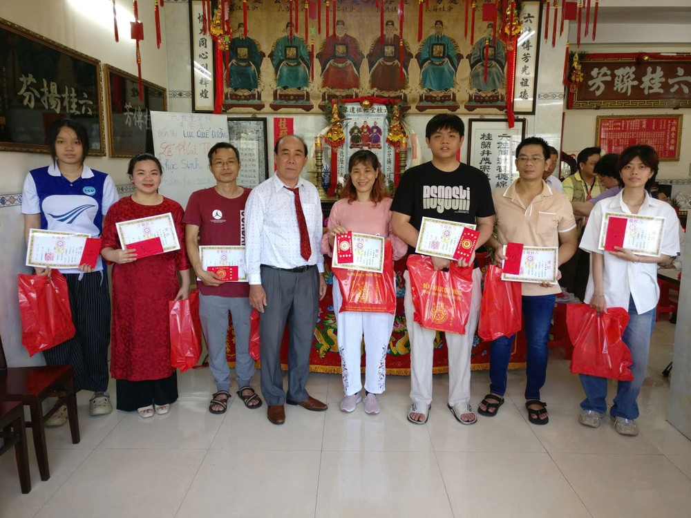 理事长方南（中）向大学生们颁奖合照。