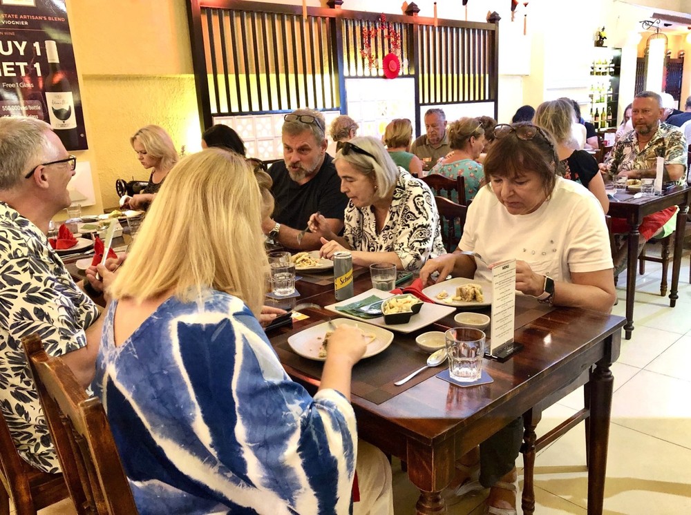 外国游客在胡志明市参加“西方人过越南年”旅游团时品尝越南春节特色菜肴。（图：越通社）