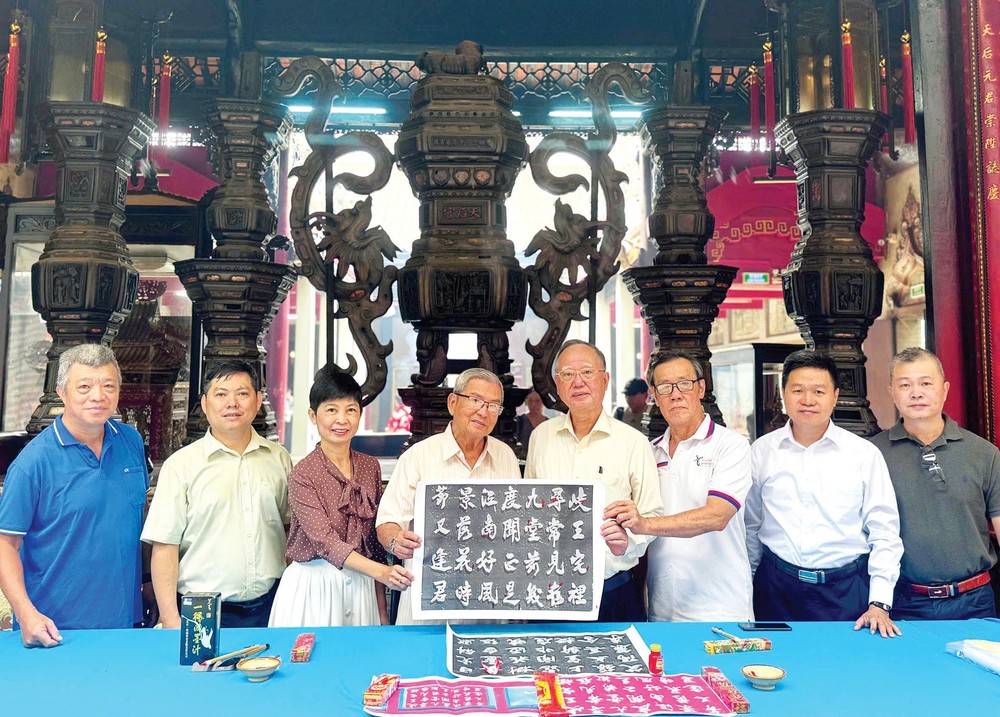 穗城会馆理事会特邀着名书画家黄献平，为天后庙模糊不清的诗句字迹进行修补。