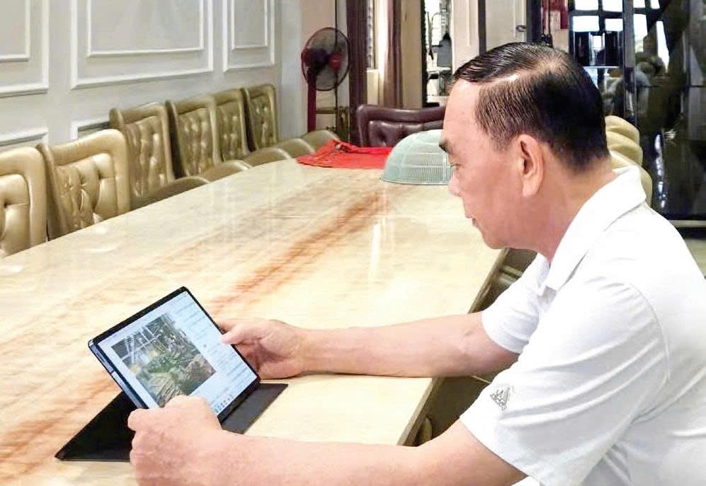 刘根全先生透过平板电脑，静阅华文电子报。