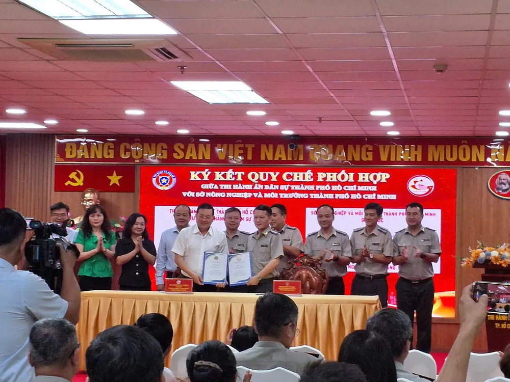 Giám đốc Sở NN-MT Nguyễn Toàn Thắng (trái) và ông Nguyễn Văn Hòa- Trưởng Thi hành án dân sự TPHCM trong nghi thức ký kết