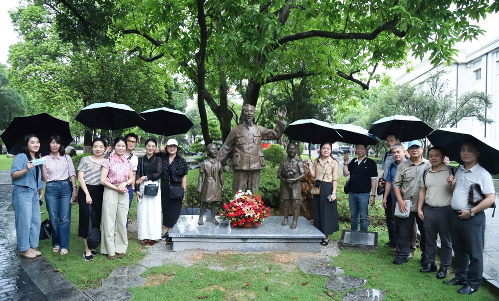  越南主要新闻机关代表团在南宁市育才学校校园内的胡志明主席塑像前合影留念。