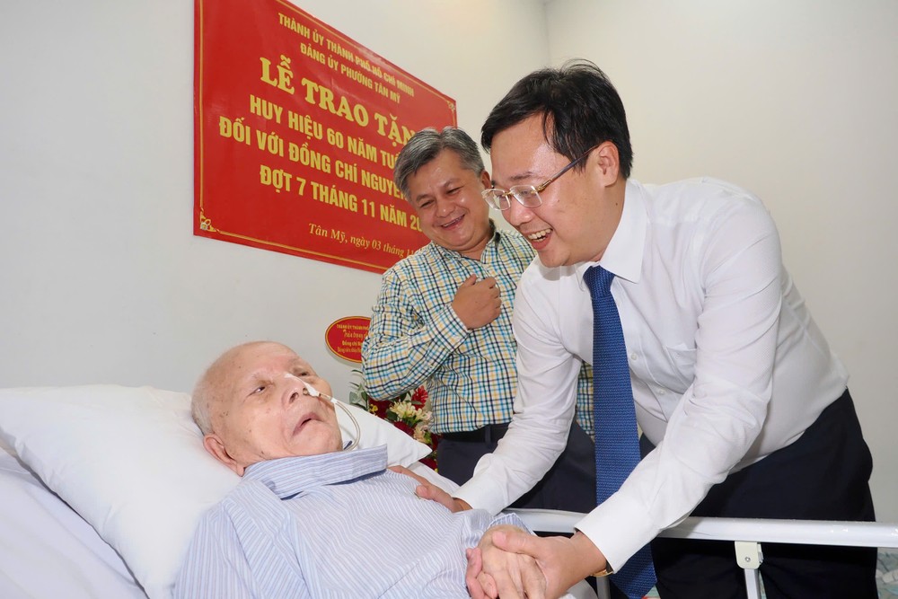 市委常务副书记黎国峰向阮维英同志颁授60年党龄纪念章。