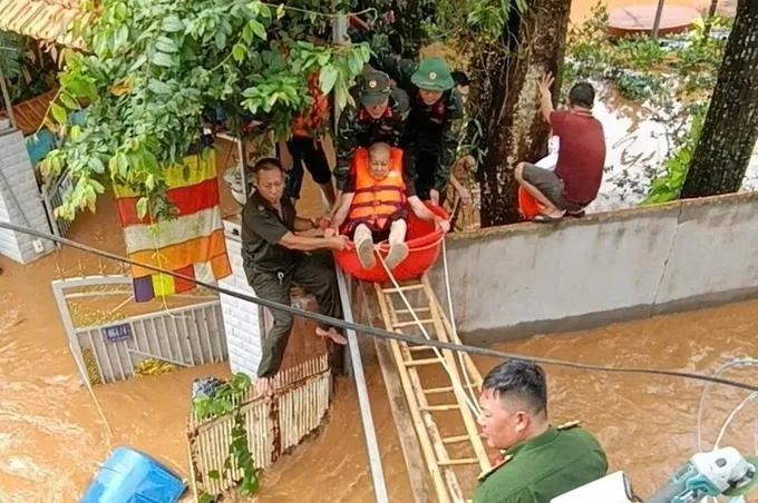 职能力量配合将被困老大娘送离隆庆坊积水较深区域。