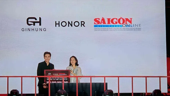  图：黎氏红绒副主任接受越南HONOR经营总监黎鸿峰象移交的 2 亿元象征性捐赠牌。