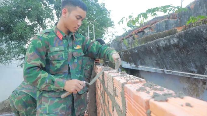  图：第34军团第10师干部、战士在德乐省山和乡为民众修建房屋。