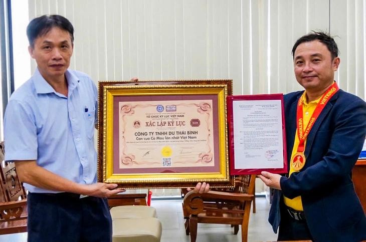余太平先生（右）接受“越南最大金瓯螃蟹”纪录认证《决定》。