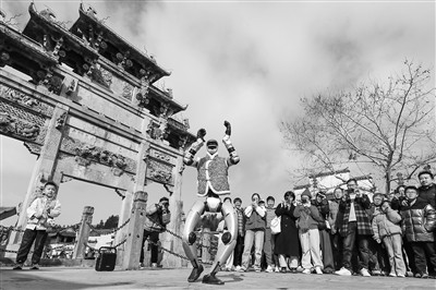 2月18日，游客在安徽省黟县西递古村观看机器人表演。新华社发（施亚磊 摄）