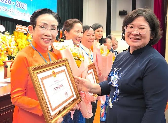 胡志明市市委副书记文氏白雪向联合会成员单位和个人颁发市人委会的奖状。