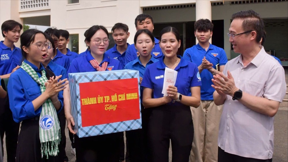  邓明通同志在红土乡隆新街市向“数字夏季”队伍赠送慰问品。