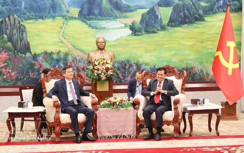 老挝人民革命党中央总书记、国家主席通伦·西苏里（右）会见前来礼节性拜会的党中央政治局委员、胡志明国家政治学院院长段明训副教授。图自越通社