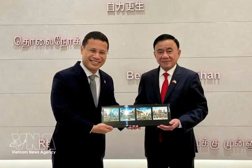 党中央政治局委员、党中央书记处常务书记陈锦秀与新加坡人民行动党主席、政府教育部长李智陞互送纪念品。图自越通社