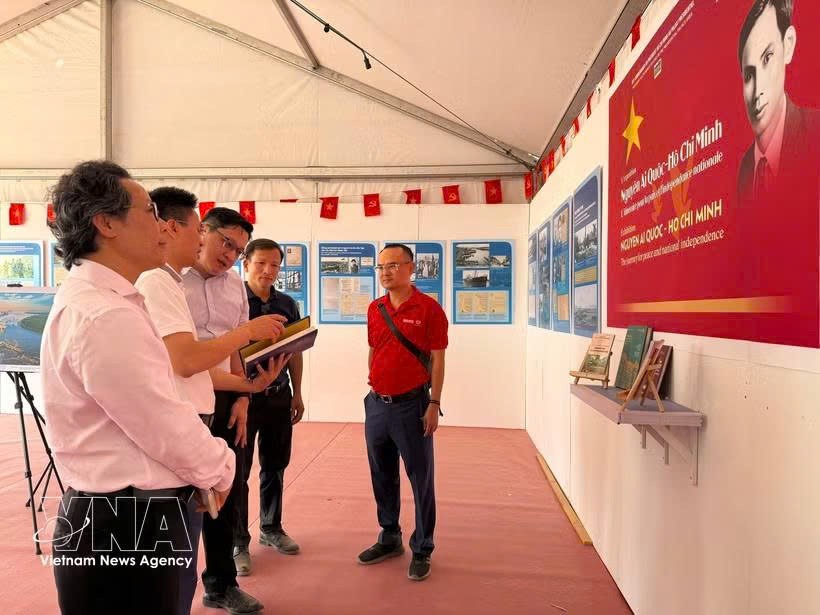 《人民报》代表向越南驻法国大使Kalamoungkhoune Souphanouvong（中）介绍有关胡志明主席和越南争取民族独立历程的展览内容。图自越通社