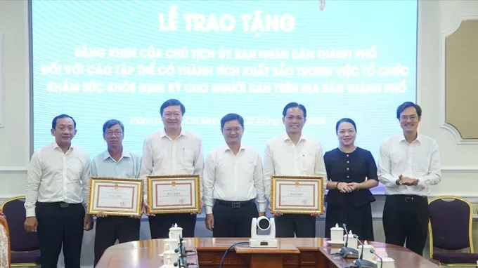 胡志明市人委会副主席阮孟强向在组织居民定期健康检查中取得优异成绩的3个集体颁发奖状。