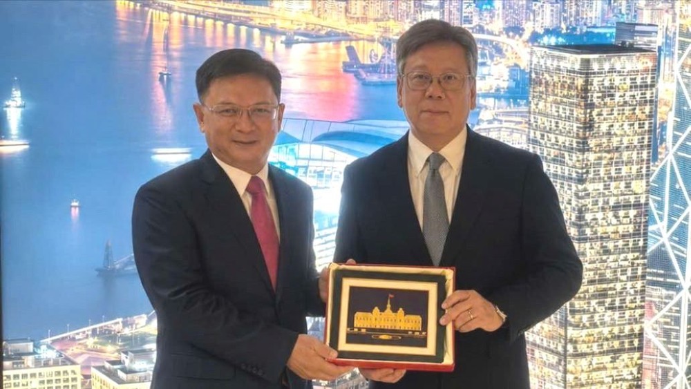 胡志明市人委会副主席阮孟强向香港特别行政区政府商务及经济发展局局长丘应桦赠送纪念品。图: 胡志明市外务厅