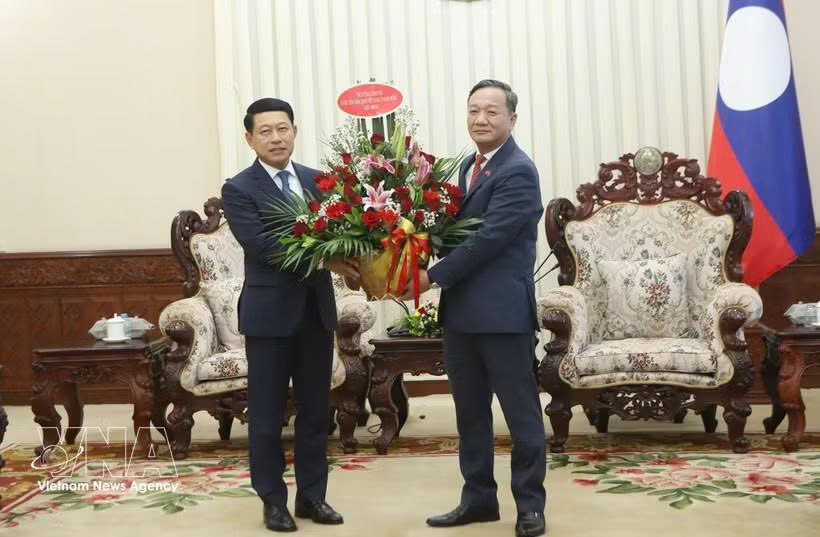阮明心大使转交越南党中央政治局委员、政府总理黎明兴致沙伦赛·贡玛西同志所致的贺信与花篮。图自越通社