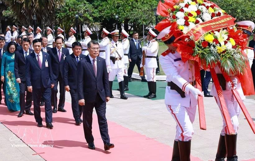 抵达瓦岱国际机场后，政府总理黎明兴及越南高级代表团随即前往首都万象无名烈士纪念碑敬献花圈。图自越通社