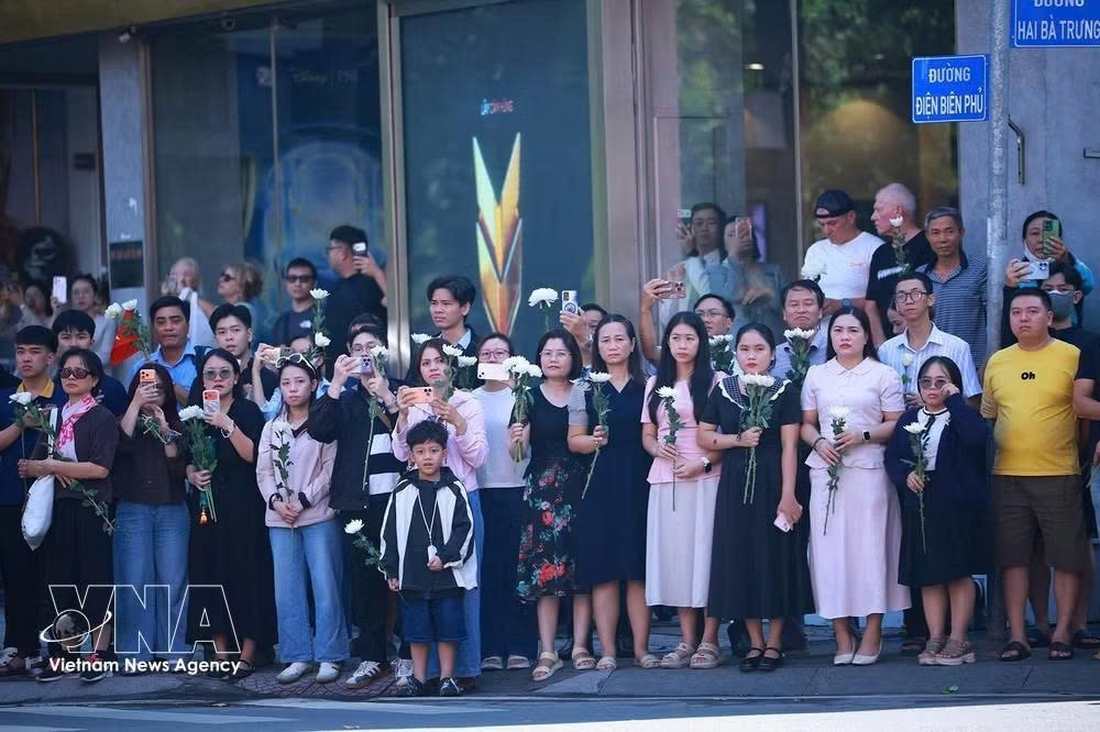 胡志明市广大市民手持白花送别烈士遗骸归葬胡志明市烈士陵园。图：越通社