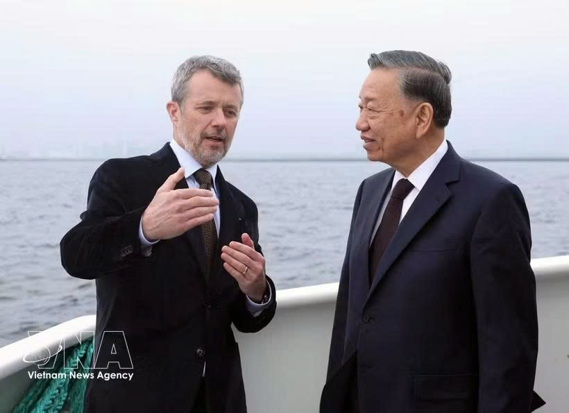 丹麦国王弗雷德里克十世在乘船前往利奈特霍尔姆岛途中，向越南党中央总书记、国家主席苏林介绍利奈特霍尔姆人造岛项目。图自越通社
