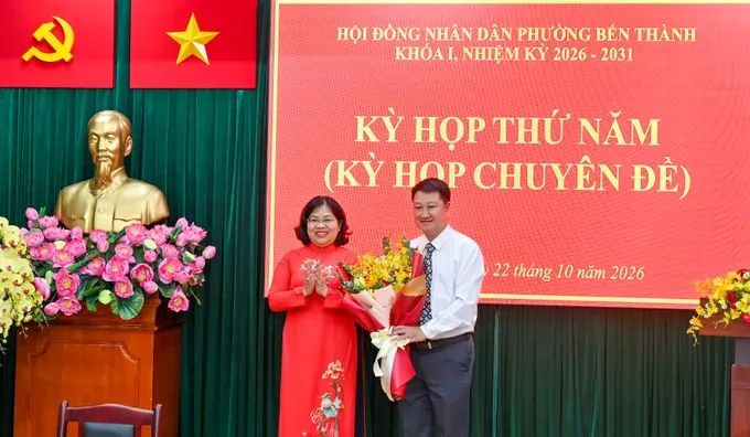 胡志明市人民议会副主席阮长日凤赠送鲜花祝贺滨城坊人委会主席。