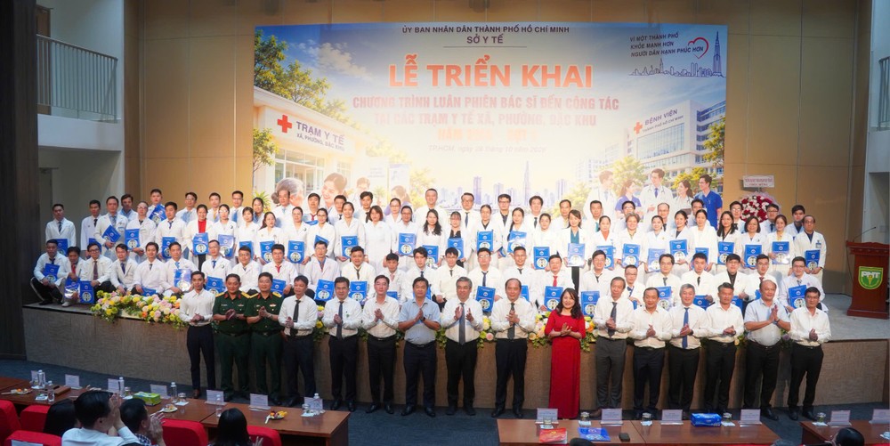 胡志明市市委副书记阮福禄与轮派前往支援37个医疗站的79名医生合影留念。图:安平 