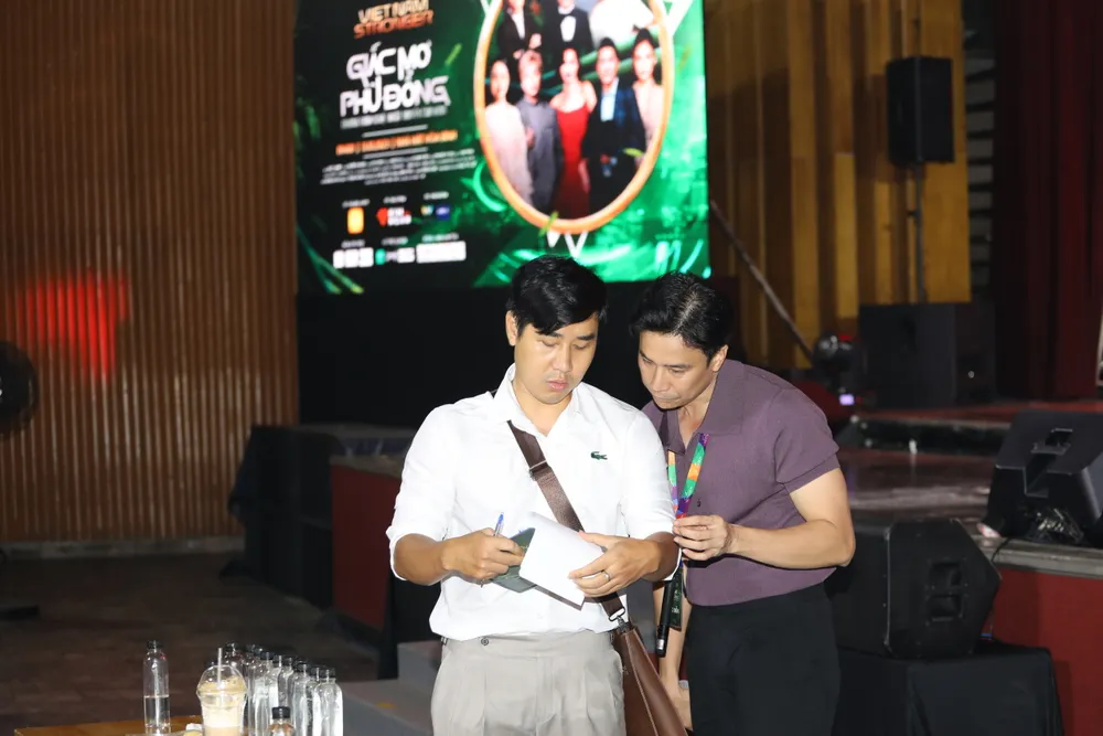 MC Nguyên Khang bàn bạc cùng đạo diễn Lê Việt. Ảnh: DŨNG PHƯƠNG