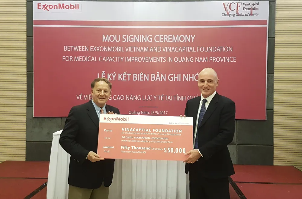 Đại diện lãnh đạo ExxonMobil trao bảng tài trợ cho đại diện Quỹ tài trợ VinaCapital. Ảnh: NGUYÊN KHÔI