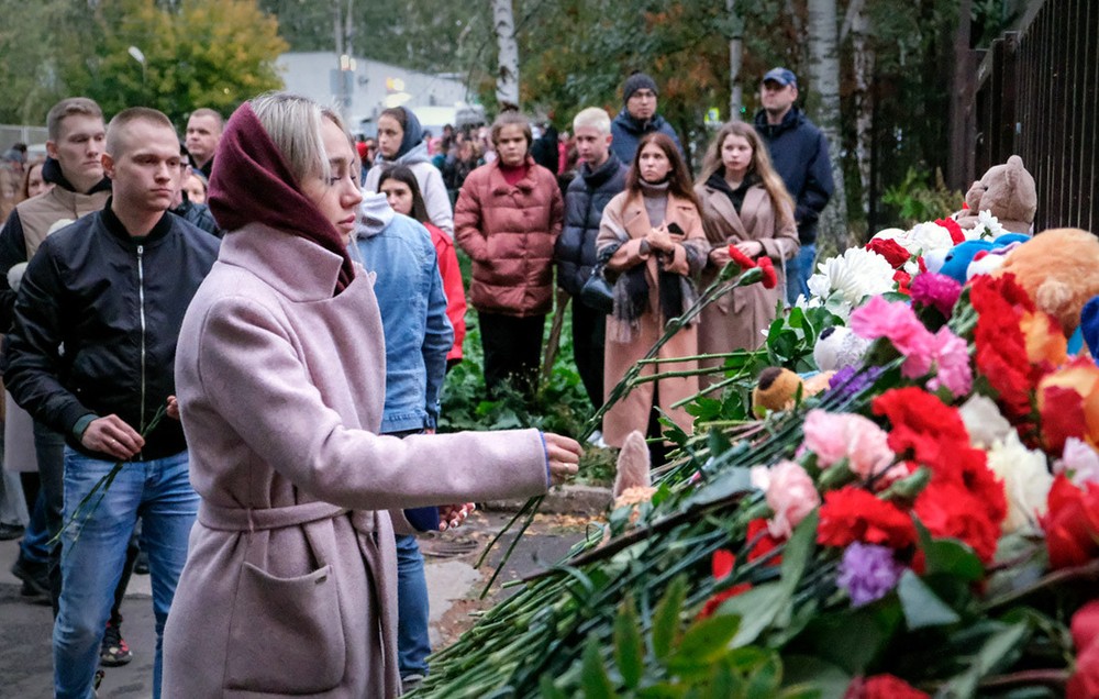 俄罗斯伊热夫斯克市第88中学枪击案造成19人死亡、23人受伤，当地居民在枪击案现场献花悼念遇难者。图：塔斯社
