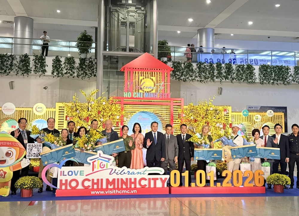 胡志明市领导及代表们与搭乘越航VN30 航班抵达胡志明市的首批8位游客合影留念。
