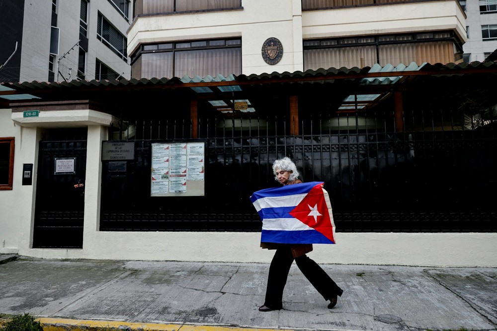 2026年3月4日，厄瓜多驻古巴原大使卡列在厄瓜多首都基多的古巴大使馆外，手持古巴国旗。图：路透社