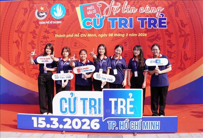 大中学生在以“年轻选民，自信同行”为主题的打卡区合影留念。