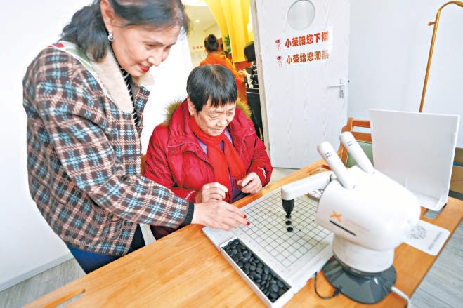 老人在驿站内与机器人对弈。图：和冠欣