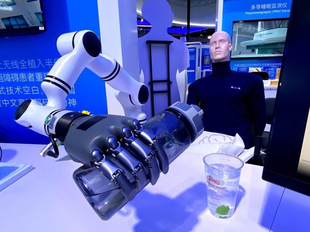 3月27日在2026中关村论坛年会展览上拍摄的“北脑一号”智能脑机系统启动机械臂往杯里倒水。图：新华社记者 魏梦佳