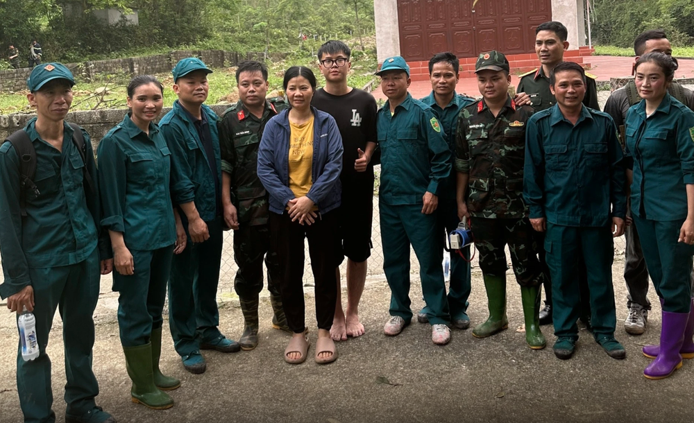 男学生和其母亲与救援队合影。