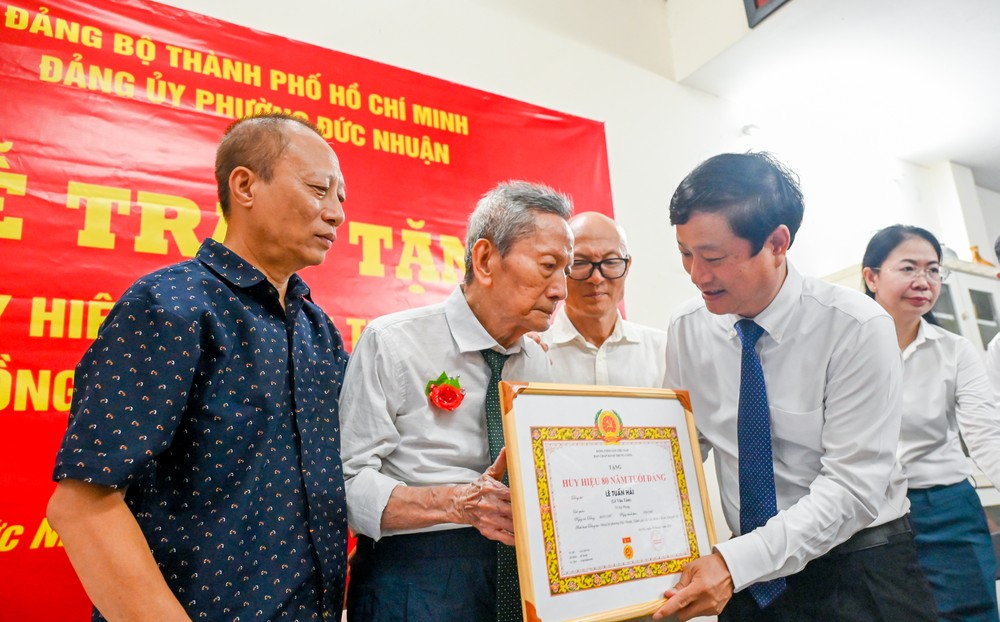 武文明同志向黎俊海同志颁发80年党龄纪念章。
