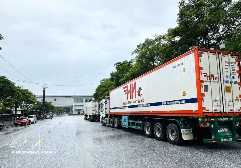 满载货物的集装箱车队在清水国际口岸区域等待办理通关手续。图：越通社